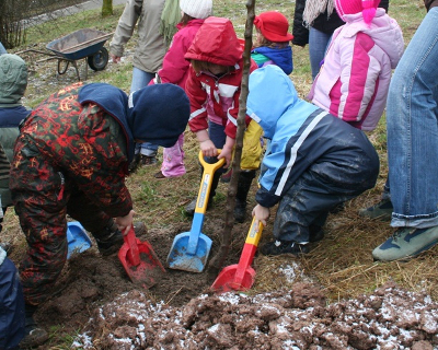 Kleinkinder graben ein Loch und pflanzen einen Baum
