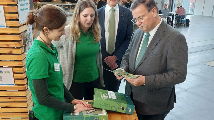 Vier Personen stehen um einen Messestand