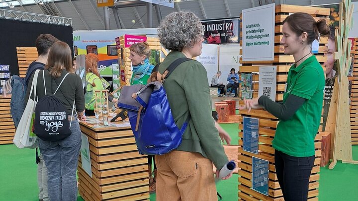 Drei Personen informieren sich am Messestand