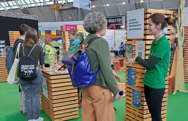 Drei Personen informieren sich am Messestand