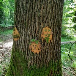 Selbstgebastelter Schmuck an einem Baumstamm