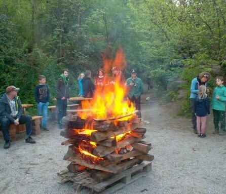 Gruppe steht um Lagerfeuer herum